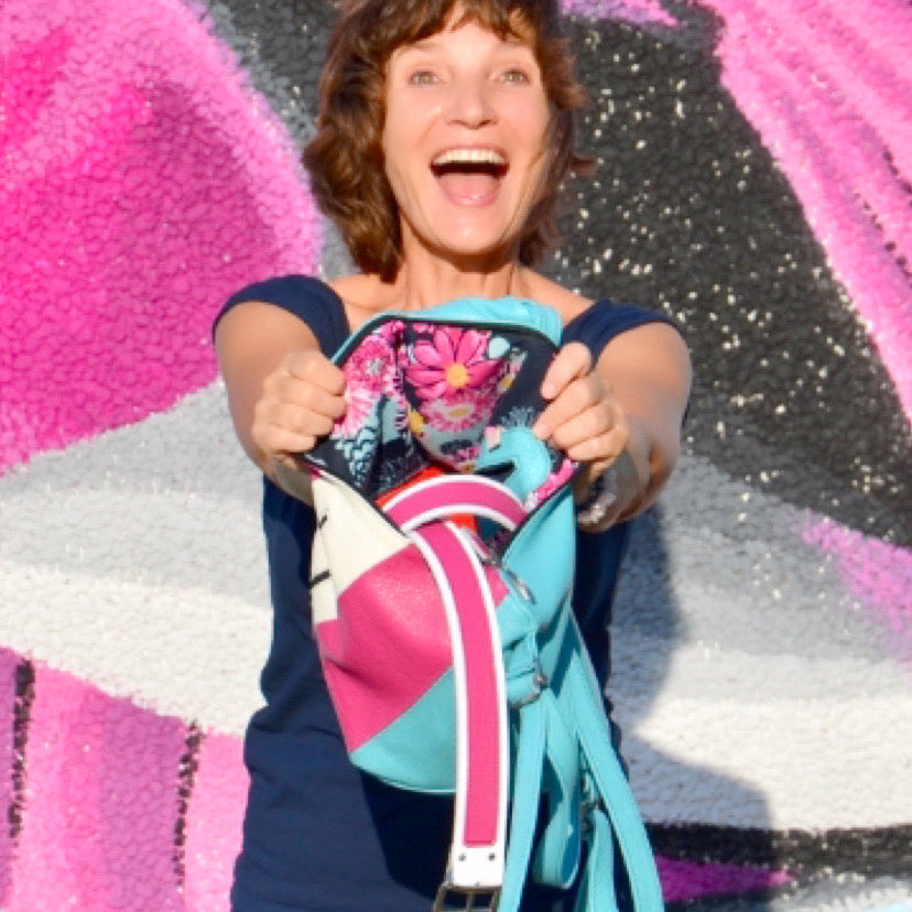 woman with a pink bag and showing  colorful belts