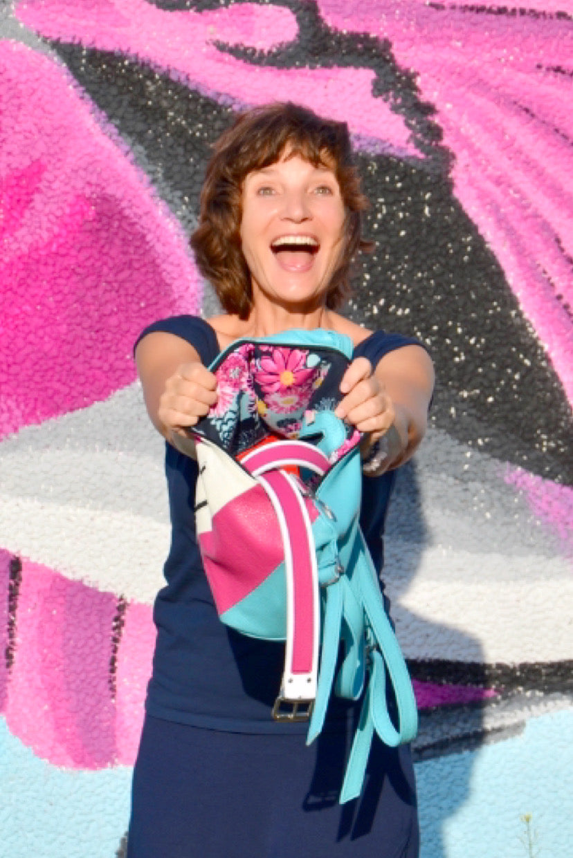 woman with a pink bag and showing  colorful belts