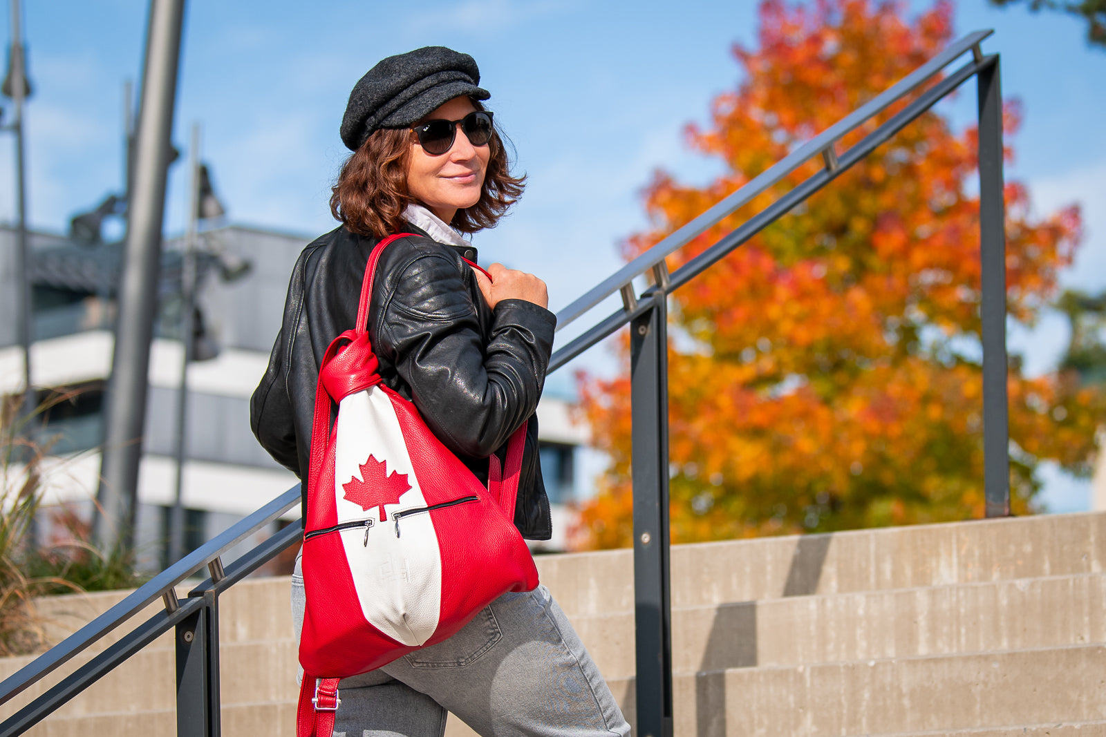 a woman with a canadian backpack outside on the stairs