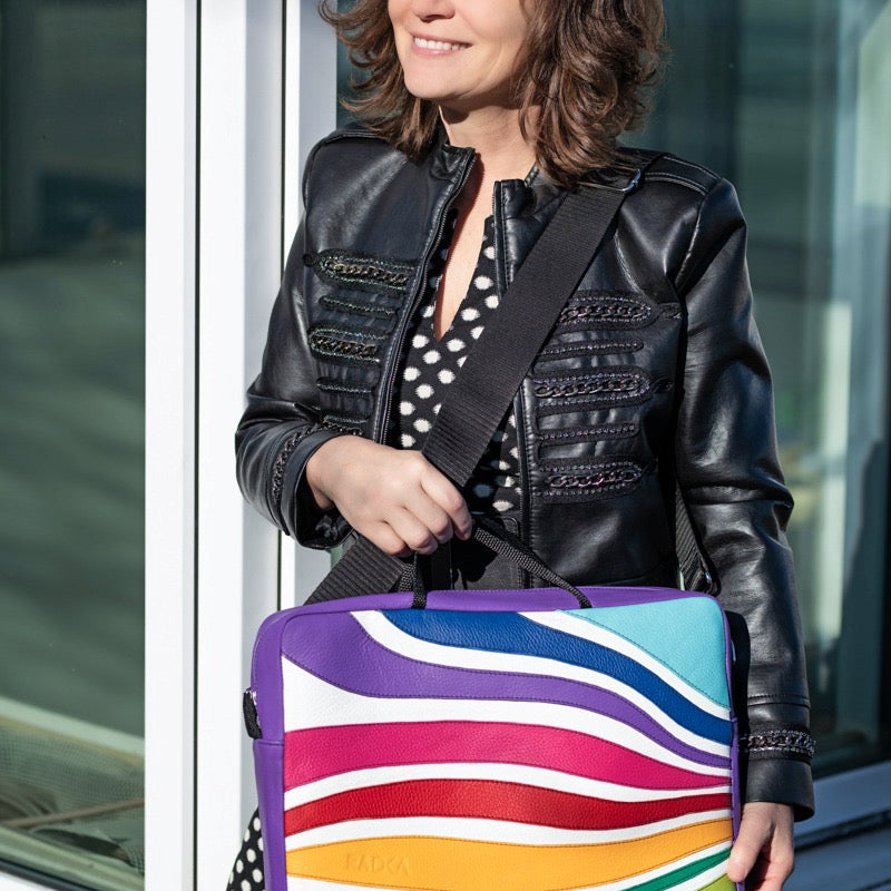 colorful laptop bag with  a woman that stands in front of a house