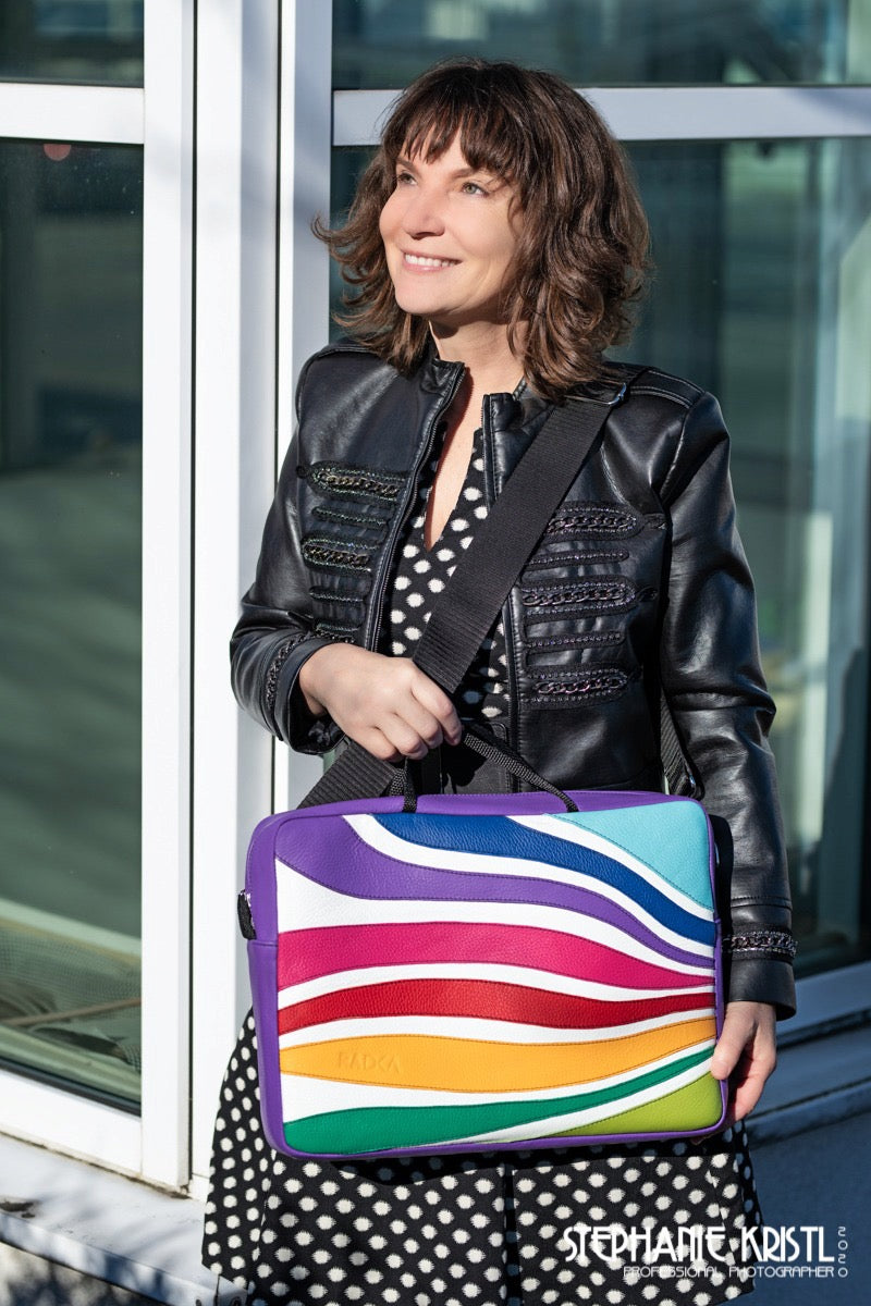 colorful laptop bag with  a woman that stands in front of a house