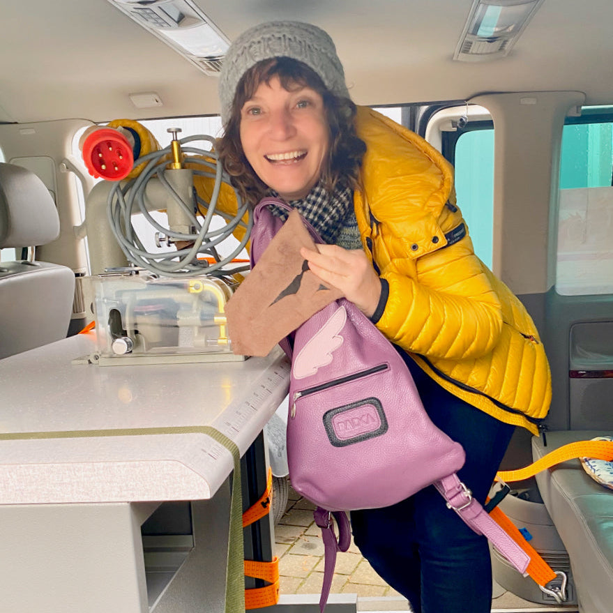 woman with a purple bag in a car and sewing machine