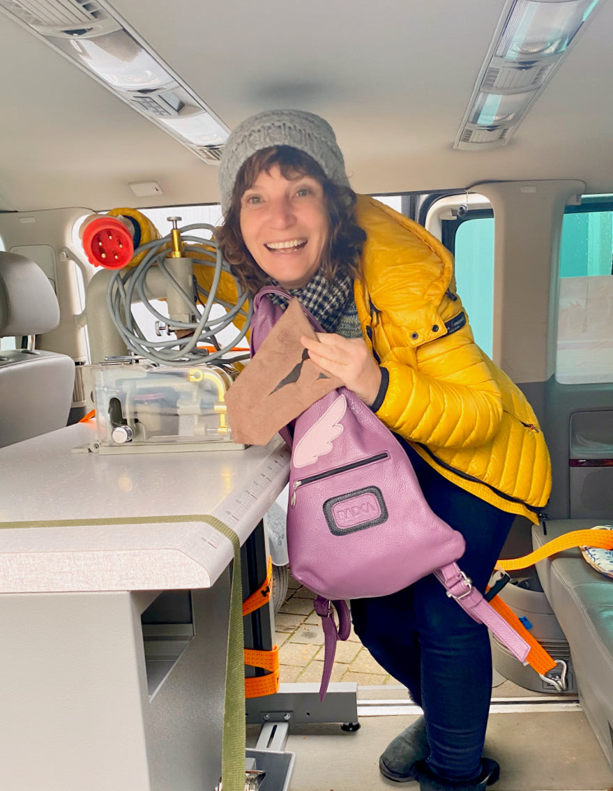 woman with a purple bag in a car and sewing machine
