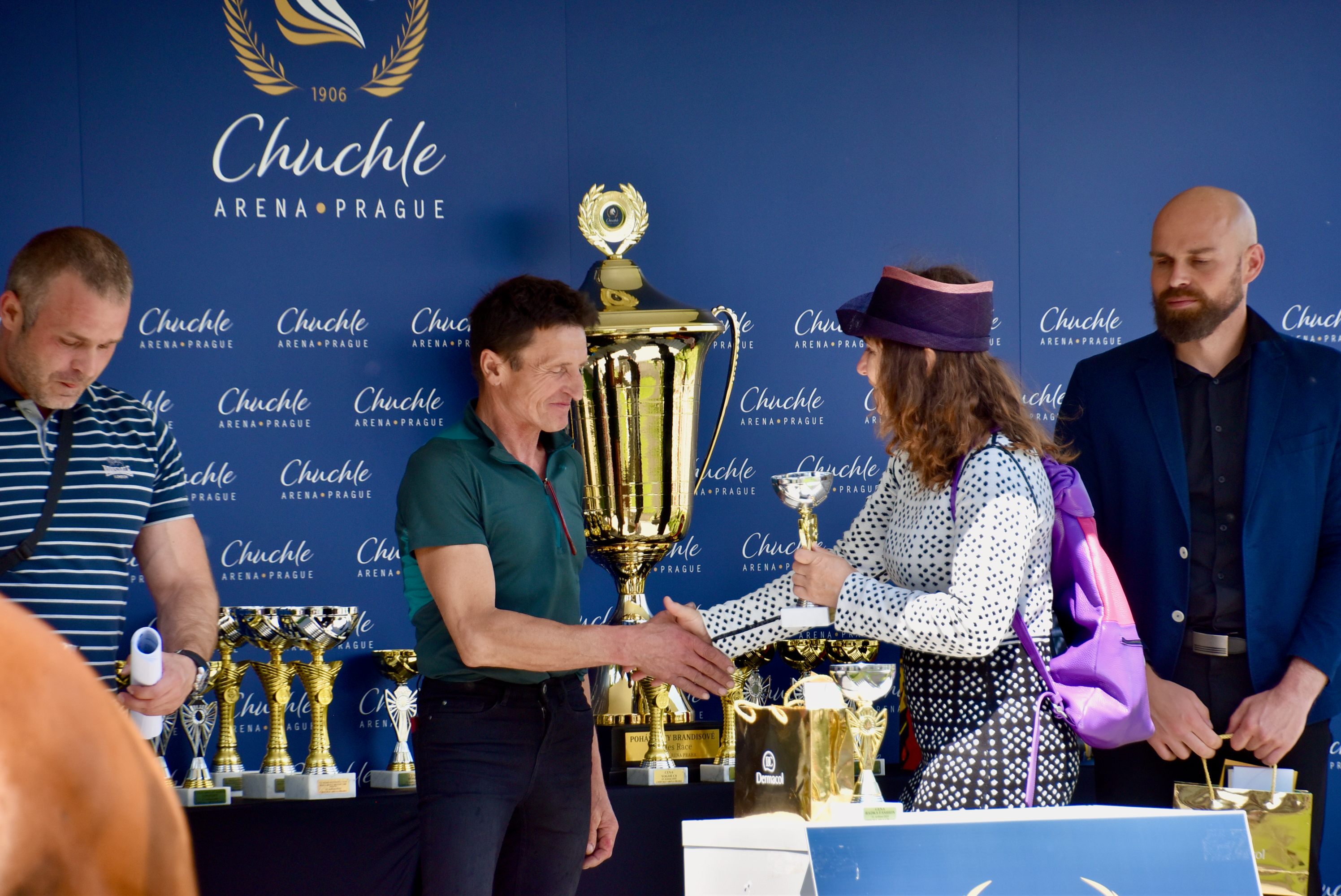 woman with backpack hands over a horse prize to a winner