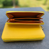 Yellow wallet on a dark surface with a blurred green background