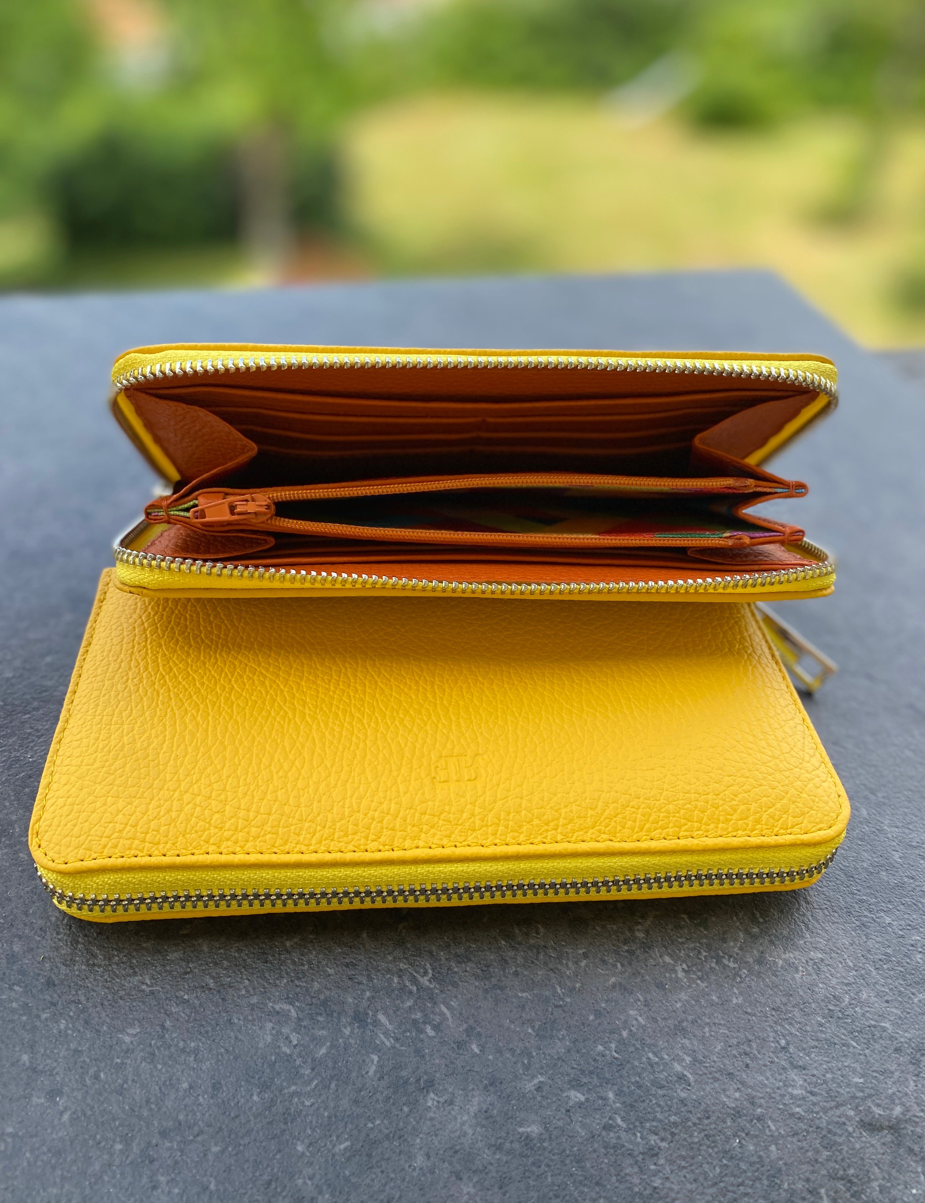 Yellow wallet on a dark surface with a blurred green background