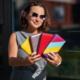 Woman holding a colorful clutch with a blurred background
