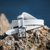White belt with a silver buckle on a rocky surface