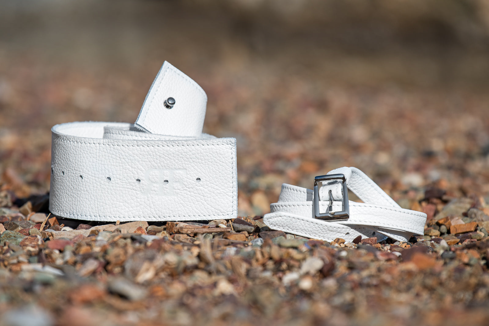 White belt with a buckle on a gravel surface