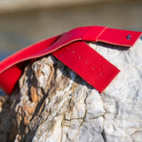 Red leather belt on a rock with a blurred natural background